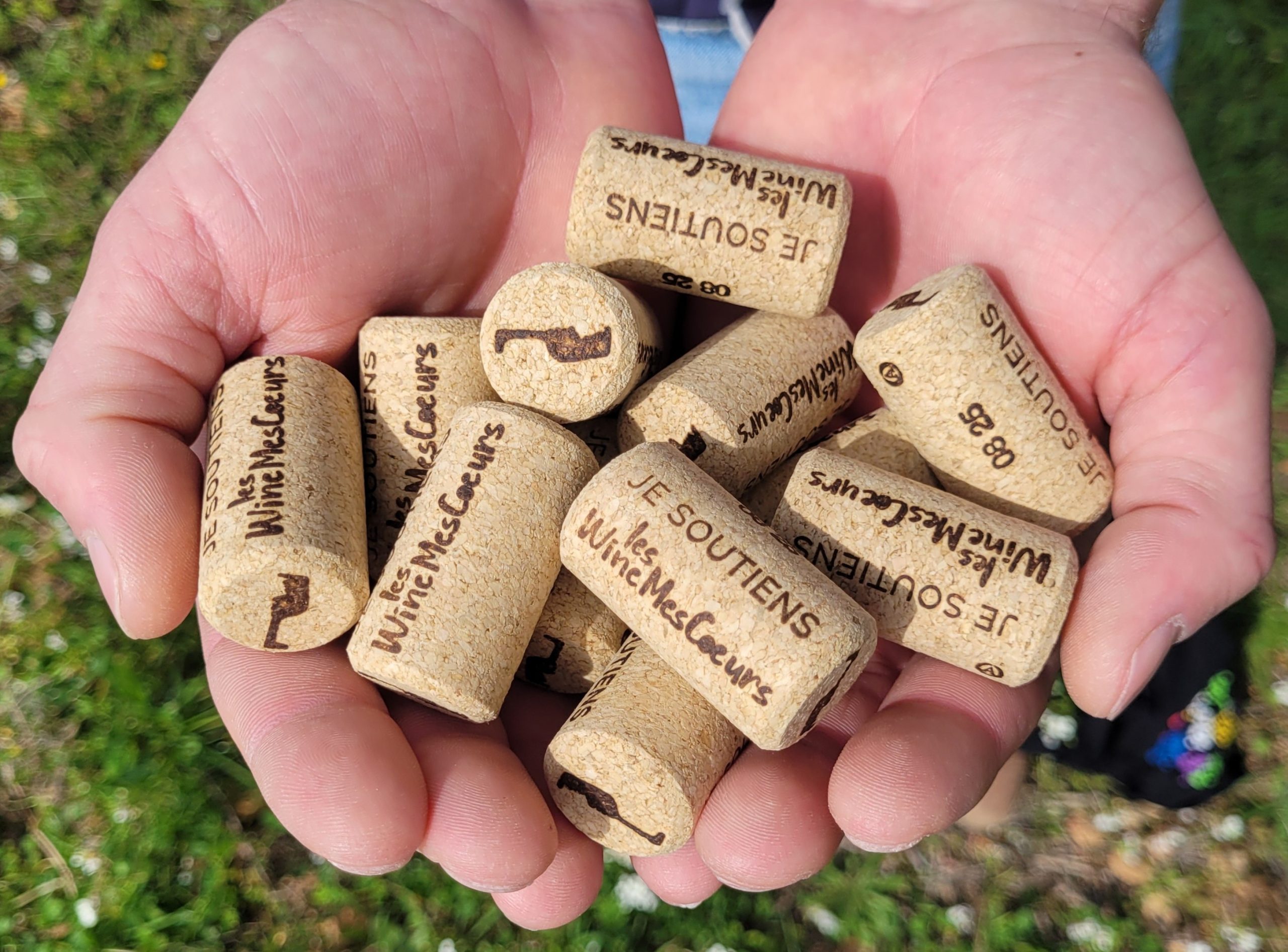 Image montrant les bouchons de vin du collectif Les WineMesCoeurs. Une inscription est gravée : "Je soutiens les WineMesCoeurs".